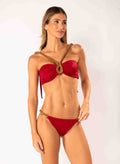 Woman wearing a red bikini with gold accents on a white background
